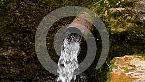 Waste pipe sewage with flowing waste water in wild nature.