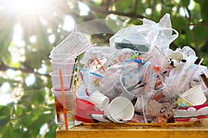 Waste plastic heap at bin, Trash full bin waste garbage, Plastic bag waste Lots of junk on nature tree sunshine background