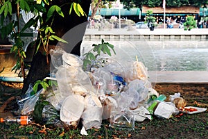 Waste plastic heap, Garbage plastic, Waste dump, Pile plastic bags and wet food waste at the the tree and river background