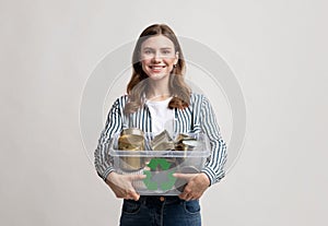 Waste Recycle. Smiling Young Woman Carrying Container Filled With Tin Cans
