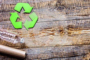 waste recycling symbol with garbage on wooden background top view mock-up