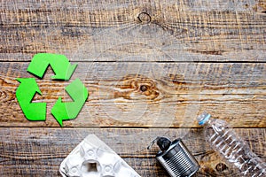 Waste recycling symbol with garbage on wooden background top view mock-up