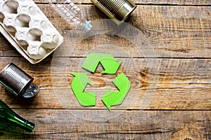 Waste recycling symbol with garbage on wooden background top view mock-up