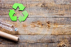 Waste recycling symbol with garbage on wooden background top view mock-up