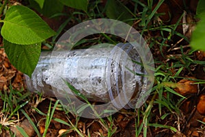 Waste and rubbish in the forest. Plastic glass.