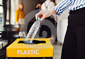 Waste separation and recycling in business office, a midsection.