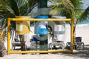 Waste separation with three trashcans at the beach