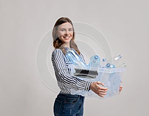 Waste Sorting Concept. Smiling Young Female Carrying Container With Empty Plastic Bottles