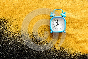 Waste of time concept. Clock on sand on black background top-down copy space