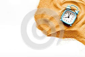 Waste of time concept. Clock on sand on white background top-down copy space