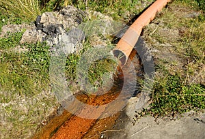 A waste water drainage pipe with flowing water polluting the environment