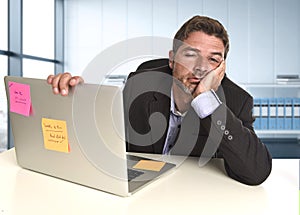 Wasted businessman working in stress at office laptop computer looking exhausted photo