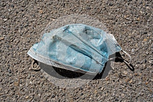 Wasted medical mask on the pavement in the street