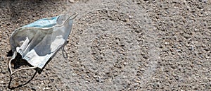 Wasted medical mask on the pavement in the street - Banner