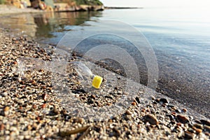 Wasted Plastic Bottle Lying On Sand Near Water, Blank Space