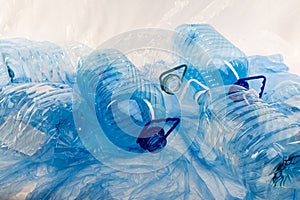 Wasted transparent water bottles placed on surface covered with plastic
