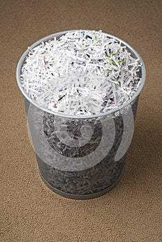 Wastepaper basket filled with shredded paper