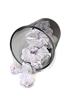 Wastepaper basket tumbled on white photo