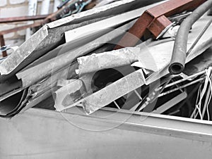 Waster metallic container bin with full with rubbish on factory in workshop. Metal scrap. Recycling