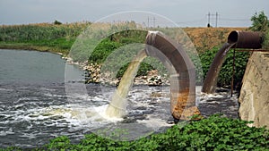 Wastewater from large rusty pipe merge into the river