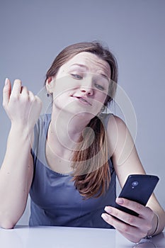 Wasting time on social media. Portrait of young beautiful woman with smartphone as symbol of social Media addiction. Psychological