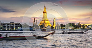 Wat Arun ,lit up,and boats on the Chao Phraya river,Bangkok,Thailand
