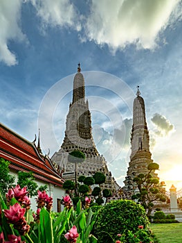 Wat Arun Ratchawararam with beautiful blue sky and white clouds. Wat Arun buddhist temple is the landmark in Bangkok, Thailand.