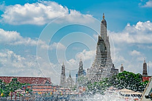 Wat Arun Ratchawararam with beautiful blue sky and white clouds. Wat Arun buddhist temple is the landmark in Bangkok, Thailand.