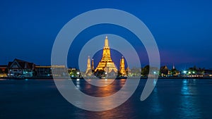 Wat Arun stupa, a significant landmark of Bangkok, Thailand, stands prominently along the Chao Phraya River, with a beautiful