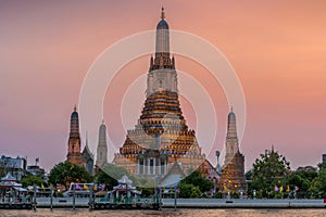 Wat Arun stupa, a significant landmark of Bangkok, Thailand, stands prominently along the Chao Phraya River, with a beautiful