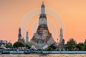 Wat Arun stupa, a significant landmark of Bangkok, Thailand, stands prominently along the Chao Phraya River, with a beautiful