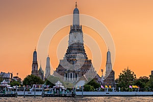 Wat Arun stupa, a significant landmark of Bangkok, Thailand, stands prominently along the Chao Phraya River, with a beautiful