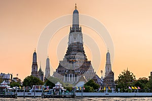 Wat Arun stupa, a significant landmark of Bangkok, Thailand, stands prominently along the Chao Phraya River, with a beautiful