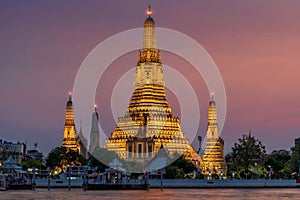 Wat Arun stupa, a significant landmark of Bangkok, Thailand, stands prominently along the Chao Phraya River, with a beautiful