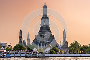 Wat Arun stupa, a significant landmark of Bangkok, Thailand, stands prominently along the Chao Phraya River, with a beautiful