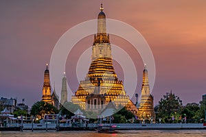 Wat Arun stupa, a significant landmark of Bangkok, Thailand, stands prominently along the Chao Phraya River, with a beautiful