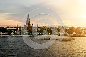 Wat Arun during sunset woth longtail boat in Chao Phraya river a