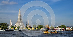 Wat Arun temple with river and transportation boat in Bangkok city