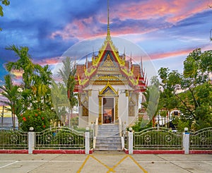 Wat Buddhist temple in Phuket Town Thailand. Decorated in colours of Gold Brown and White. Sunset Sunrise lovely sky