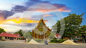 Wat Buddhist temple in Phuket Town Thailand. Decorated in colours of Gold Brown and White. Sunset Sunrise lovely sky