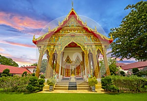 Wat Buddhist temple in Phuket Town Thailand. Decorated in colours of Gold Brown and White. Sunset Sunrise lovely sky