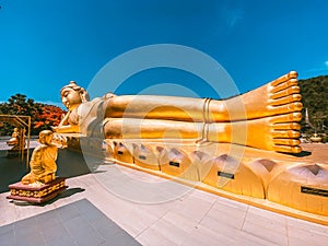 Wat Khao Sung Chaem Fa temple with giant snake and reclining gold buddha, in Kanchanaburi, Thailand