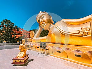 Wat Khao Sung Chaem Fa temple with giant snake and reclining gold buddha, in Kanchanaburi, Thailand