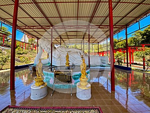 Wat Khao Sung Chaem Fa temple with giant snake and reclining gold buddha, in Kanchanaburi, Thailand