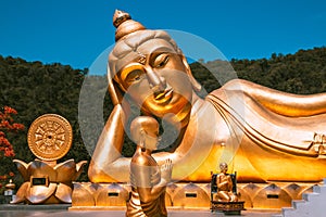 Wat Khao Sung Chaem Fa temple with giant snake and reclining gold buddha, in Kanchanaburi, Thailand