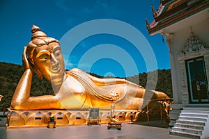 Wat Khao Sung Chaem Fa temple with giant snake and reclining gold buddha, in Kanchanaburi, Thailand