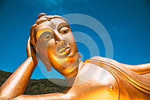 Wat Khao Sung Chaem Fa temple with giant snake and reclining gold buddha, in Kanchanaburi, Thailand