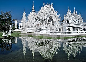 Wat Rong Khun is reflected in lake as in a mirror