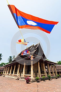 Wat Sisaket with colourful Buddhist religious flags on foreground in Vientiane, Laos