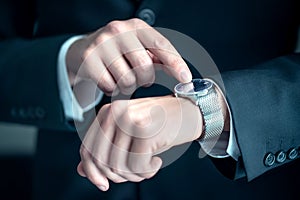 Watch around the wrist of a stylish business man. Busy businessman looking at the time. Stress or hurry at work.